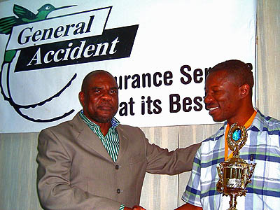 NM Geoffrey Byfield (right) receives the Dr. Harold Chan Trophy from JCF President Ian Wilkinson. Photo by Jamaican Chess Federation.