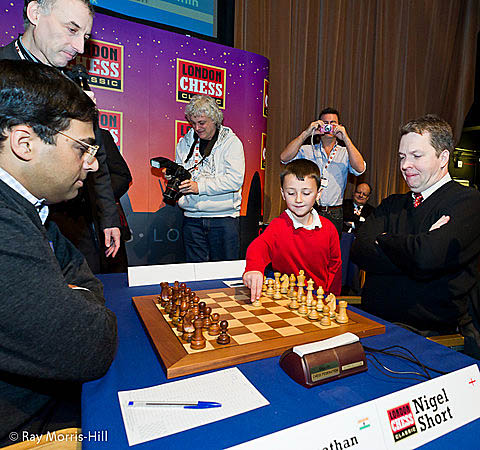 This picture of the boy playing the ceremonial move may be worth something ten years from now. Are we looking at a future English GM? If so, he is in distinguished company includin GM John Nunn in the background. Photo by Ray Morris-Hill.